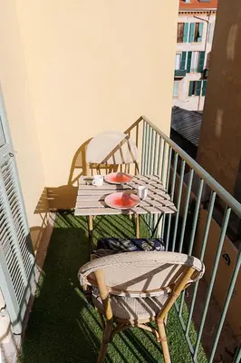 a table and a chair on a balcony at charmant studio sur le port de Nice in Nice