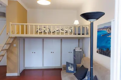 a living room with a couch and a staircase at charmant studio sur le port de Nice in Nice