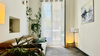 a living room with a couch and a large window at Bel appartement 2 pièces à Nice in Nice