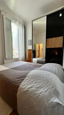a bedroom with a large bed with a large mirror at Bel appartement 2 pièces à Nice in Nice