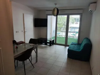 a living room with a table and a couch at Appartement deux pièces bien situé et pratique in Nice