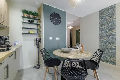 a kitchen with a table and chairs and a clock on the wall at Appartement confort centre ville de Nice in Nice