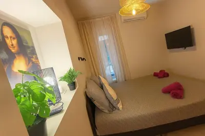 a small bedroom with a bed and a window at Central- walk to Massena & Beach in Nice