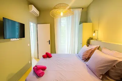 a bedroom with a large bed with red pillows on it at Central- walk to Massena & Beach in Nice