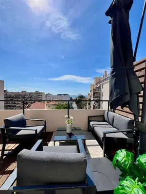a balcony with chairs and tables on a roof at TheNiceTerrace in Nice