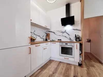 a kitchen with white cabinets and a microwave at Cosy Savoie by Bookking Guys in Nice
