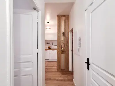 a hallway with a white door and a kitchen at Cosy Savoie by Bookking Guys in Nice