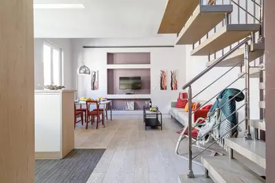 a living room with a staircase and a dining room at MY CASA - FRANCE 82 - 2 rooms -1 min from the Sea - Parking in Nice