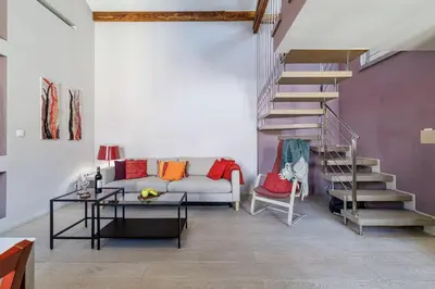 a living room with a couch and a spiral staircase at MY CASA - FRANCE 82 - 2 rooms -1 min from the Sea - Parking in Nice
