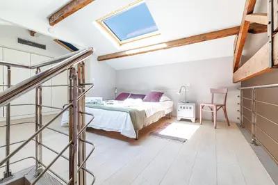 a attic bedroom with a bed and a staircase at MY CASA - FRANCE 82 - 2 rooms -1 min from the Sea - Parking in Nice