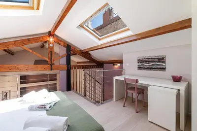 a attic room with a desk and a table at MY CASA - FRANCE 82 - 2 rooms -1 min from the Sea - Parking in Nice