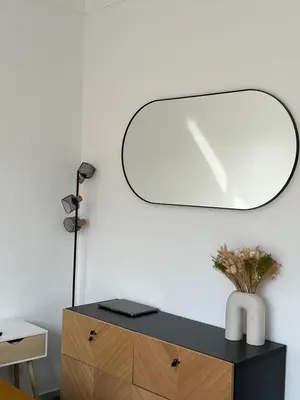 a mirror on top of a dresser with a vase at 2 Pièce - Promenade des Anglais in Nice