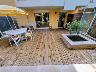 a patio with a table and chairs and an umbrella at Ferber Garden - Appartement de charme avec deck privé in Nice