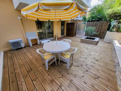 a patio with a table and chairs and an umbrella at Ferber Garden - Appartement de charme avec deck privé in Nice