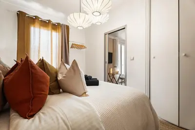 a bedroom with a bed with pillows and a mirror at Nice Renting - 35b MASSENA - Chic Cosy Calm Balcony Massena Pedestrian Heart in Nice
