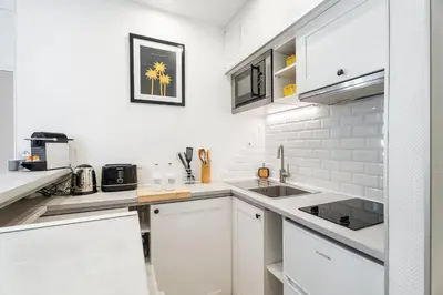 a white kitchen with white cabinets and a sink at Nice Renting - 35b MASSENA - Chic Cosy Calm Balcony Massena Pedestrian Heart in Nice