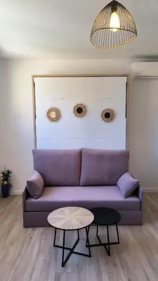 a living room with a purple couch and a table at Studio La Madrague Côte d'Azur in Cros-de-Cagnes