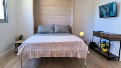 a bedroom with a bed with a wooden headboard at Studio La Madrague Côte d'Azur in Cros-de-Cagnes