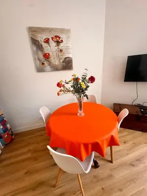 a orange table with a vase of flowers on it at Studio Smile FSHH in Nice