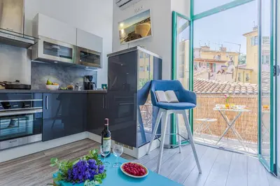 a kitchen with a blue chair and a table at MY CASA - CASSINI - Garibaldi Square - AC in Nice