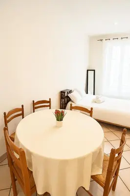 a room with a table and chairs and a bed at Charming & roomy apartment with balcony heart of Nice in Nice