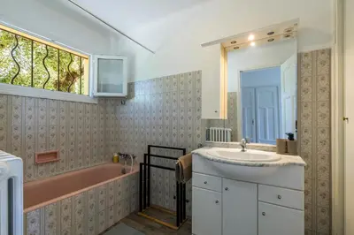 a bathroom with a sink and a pink bath tub at Villa les Oliviers in La Gaude