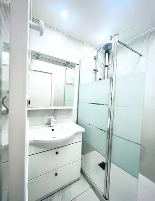 a white bathroom with a sink and a shower at Sweet Suite Nice in Nice