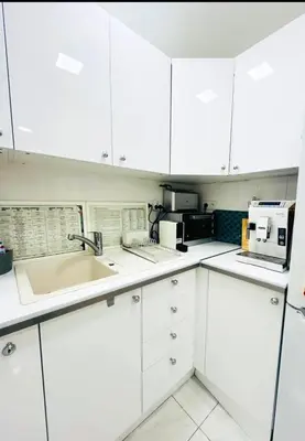a kitchen with white cabinets and a sink at Sweet Suite Nice in Nice