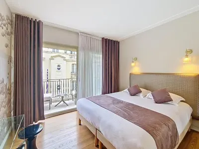 a bedroom with a large bed and a balcony at Nestor&Jeeves - VICTORIA - Delux apartment city center in Nice