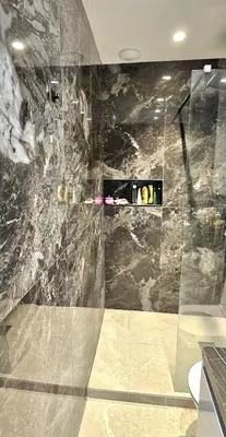 a bathroom with a shower with a marble wall at Grand Studio Luxe in Nice