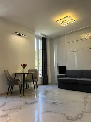 a living room with a table and a couch at Grand Studio Luxe in Nice