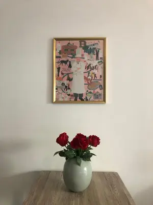 a vase with red roses on a table under a picture at Le Clio Hyper Centre proche Promenade in Nice
