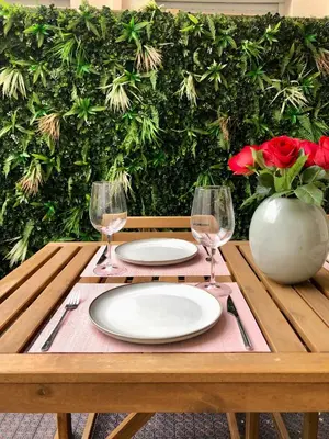 a wooden table with two plates and two wine glasses at Le Clio Hyper Centre proche Promenade in Nice