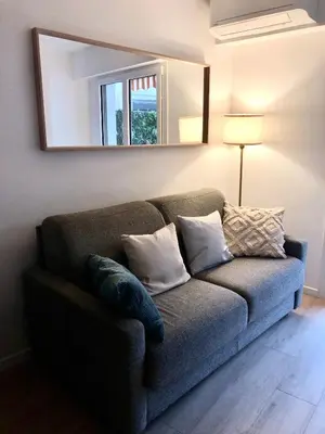 a couch in a living room with a mirror at Le Clio Hyper Centre proche Promenade in Nice