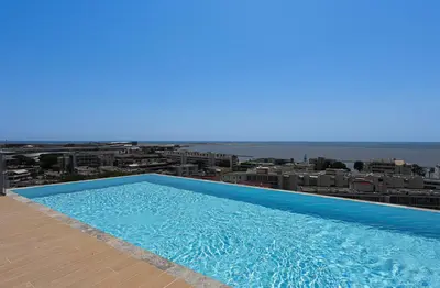 a large blue swimming pool on top of a building at Ciel d'Azur - Climatisé piscine partagée in Saint-Laurent-du-Var