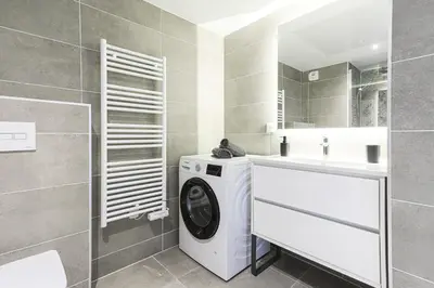 a bathroom with a washing machine and a sink at Ciel d'Azur - Climatisé piscine partagée in Saint-Laurent-du-Var