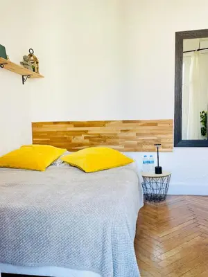 a bedroom with a bed with a mirror and a chandelier at Studio in the center balcony AC in Nice