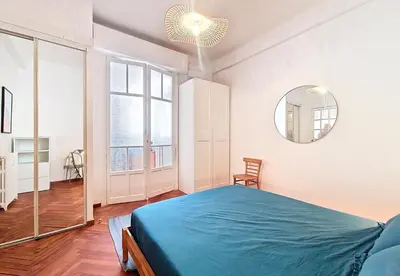 a bedroom with a blue bed and a mirror at Nestor&Jeeves - PALAIS DE LA SIRENE - Near Promenade des Anglais in Nice