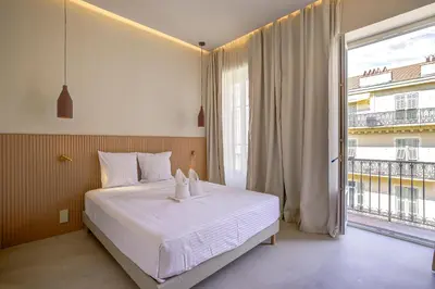 a bedroom with a bed and a large window at Grand appartement Centre de Nice in Nice