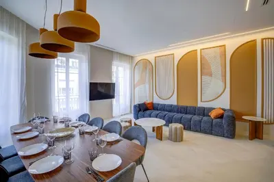 a dining room with a table and chairs and a couch at Grand appartement Centre de Nice in Nice