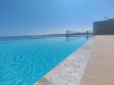 a swimming pool with blue water next to a building at SEA SIDE - Rooftop Pool SeaView in Saint-Laurent-du-Var
