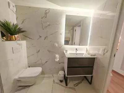 a bathroom with a sink and a toilet and a mirror at SEA SIDE - Rooftop Pool SeaView in Saint-Laurent-du-Var