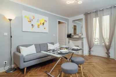 a living room with a couch and a table at Le Chic, appartement plein centre avec Climatisation in Nice