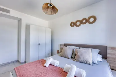 a bedroom with a large bed with towels on it at Chez Valentina et Alexandre Port et plages à pied in Saint-Laurent-du-Var