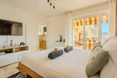 a white bedroom with a large bed with two pillows at Studio Terrace AC Lift - Old town | By Airnest in Nice