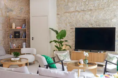 a living room with a flat screen tv on a stone wall at Extra Spacious Modern Apartment HUB Nice Center in Nice