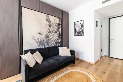 a living room with a black couch and a rug at Oasis Azur 1 min from the beach in Nice