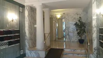 a hallway with a staircase with a pillar and a mirror at Baquis in Nice