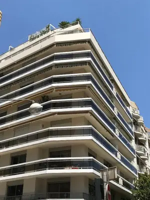 an apartment building with balconies and a blue sky at Baquis in Nice