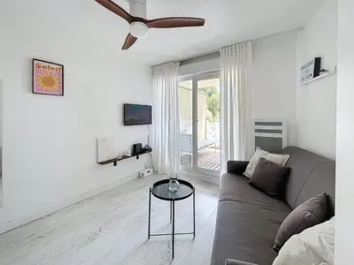 a living room with a couch and a ceiling fan at Studio Neuf avec Terrasse et Aperçu Mer in Nice